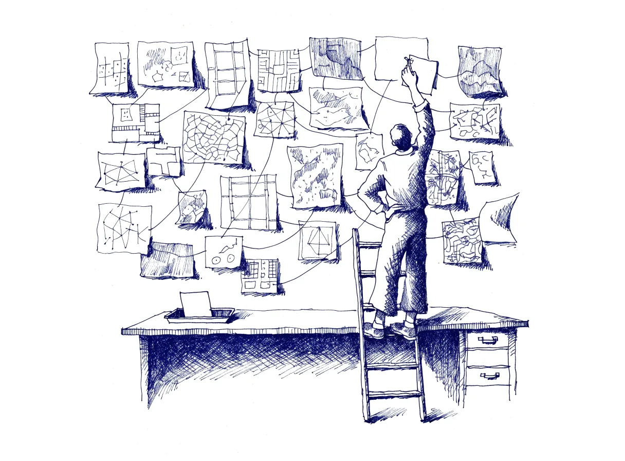 A figure on a short ladder re-pins a loose sheet on a wall covered with sketches, maps and notes joined by string, while a single small card lies in a tray on the desk below.